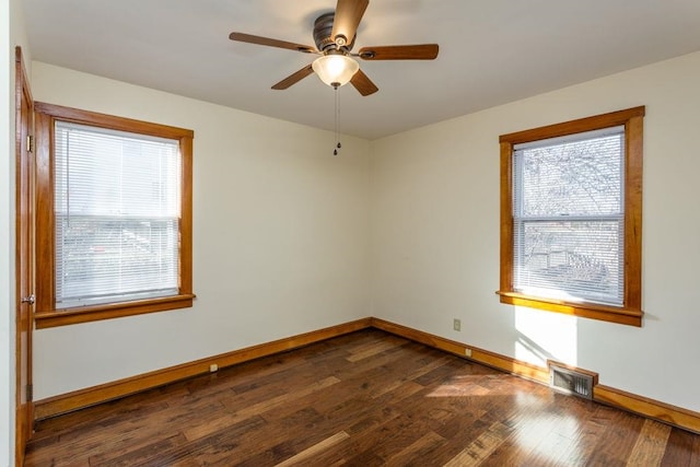 empty room featuring dark hardwood / wood-style flooring, plenty of natural light, and ceiling fan