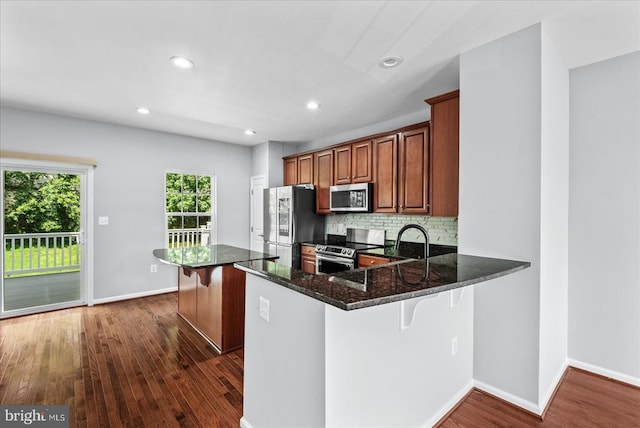 4631 Alliance Way, Fredericksburg, VA 22408 - kitchen featuring stainless steel appliances, dark wood finished floors, dark stone countertops, tasteful backsplash, and a breakfast bar