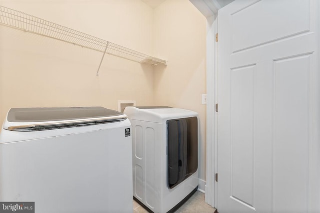 washroom with independent washer and dryer and light tile patterned flooring