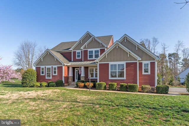 craftsman inspired home featuring board and batten siding, a front lawn, a standing seam roof, and a porch
