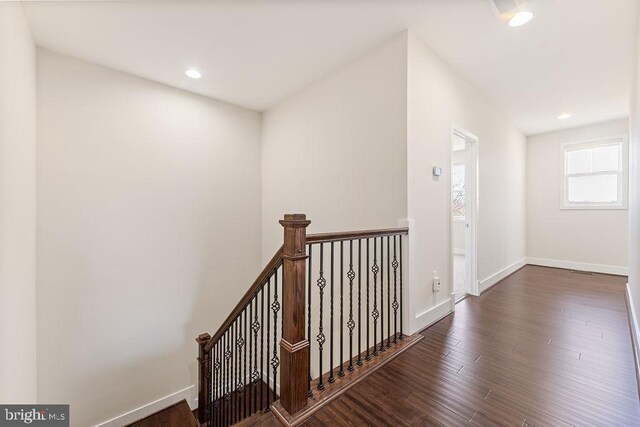 empty room featuring a chandelier, ornamental molding, dark wood-style floors, arched walkways, and baseboards