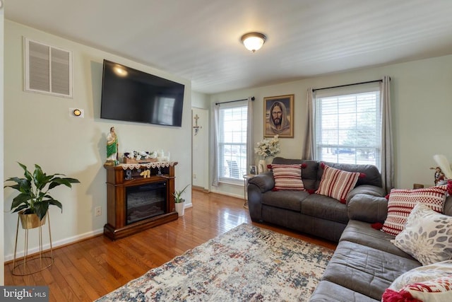 living area featuring hardwood / wood-style flooring and baseboards