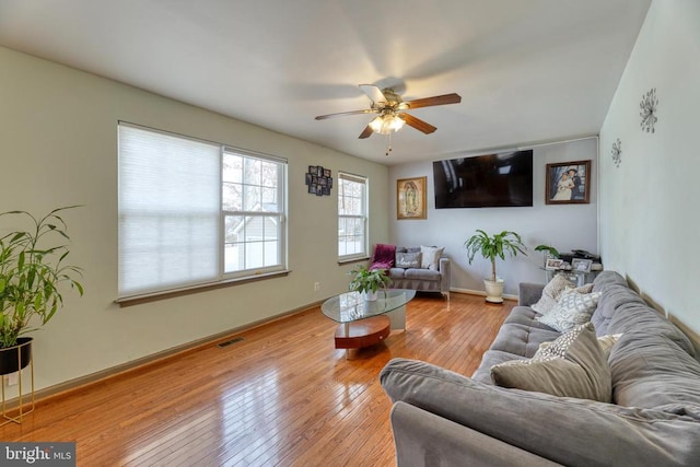 living room featuring a ceiling fan, hardwood / wood-style floors, and baseboards