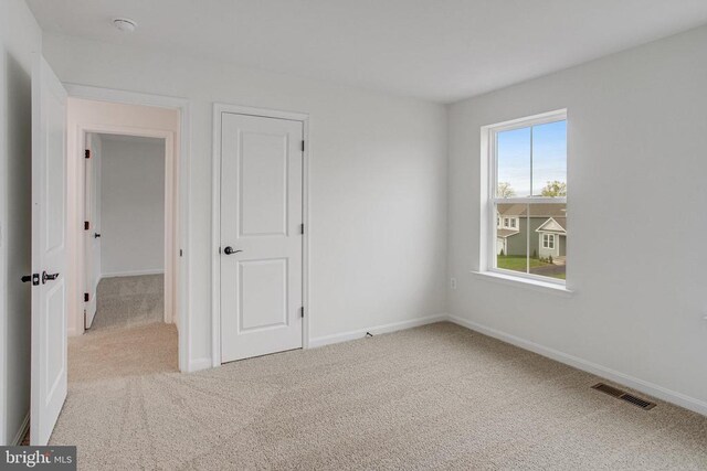 unfurnished bedroom featuring carpet floors and baseboards