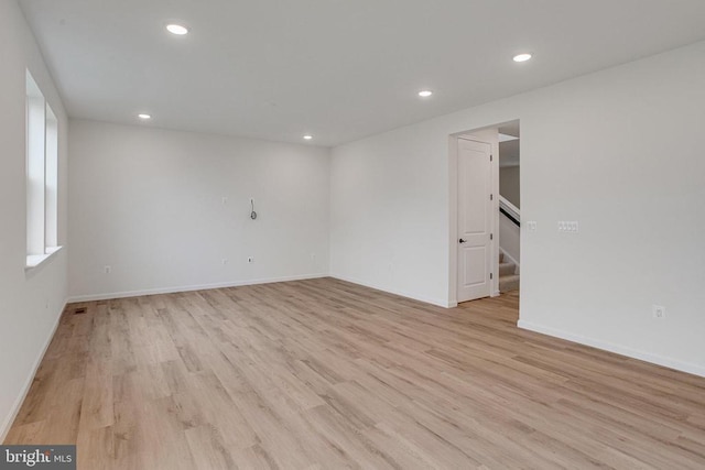 unfurnished room featuring light wood-style flooring, recessed lighting, stairs, and baseboards