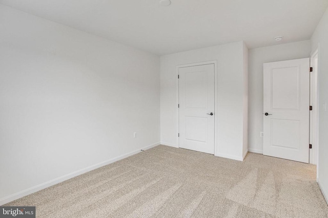 unfurnished bedroom featuring carpet and baseboards