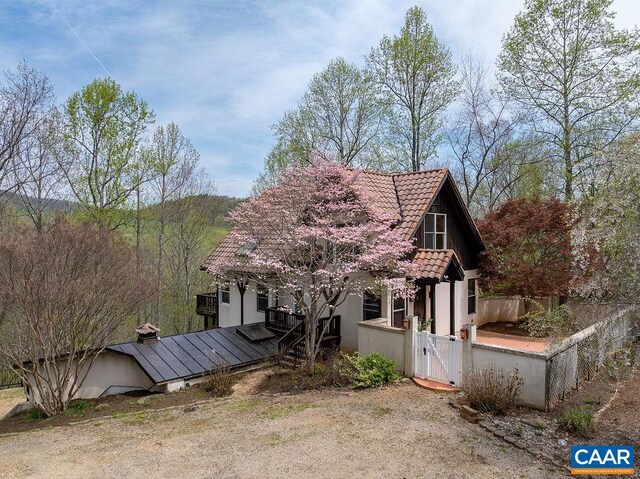 7035 Blackwells Hollow Rd, Crozet, VA 22932 - view of front of house featuring a gate, a tile roof, a wooden deck, and stucco siding