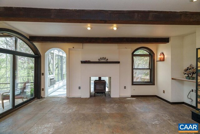 7035 Blackwells Hollow Rd, Crozet, VA 22932 - unfurnished living room with beam ceiling, a wood stove, healthy amount of natural light, and baseboards