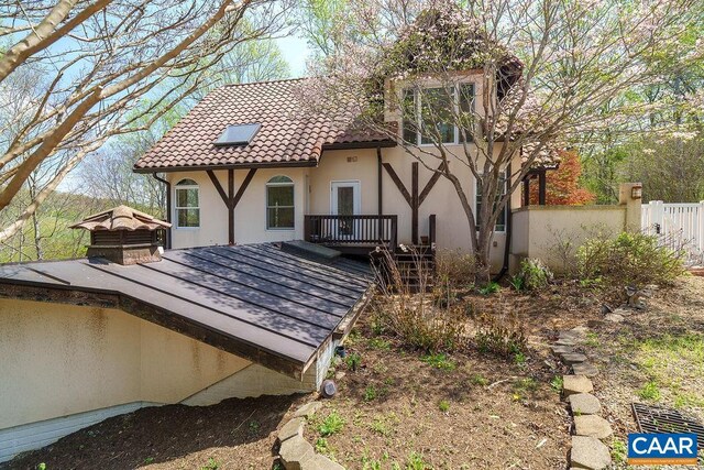 7035 Blackwells Hollow Rd, Crozet, VA 22932 - rear view of house featuring a wooden deck, fence, stucco siding, and a tile roof