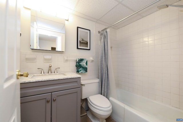 bathroom with shower / tub combo with curtain, vanity, toilet, and tile walls