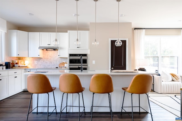 3076 Horizon Rd, Charlottesville, VA 22902 - kitchen featuring a breakfast bar, stainless steel double oven, white cabinetry, backsplash, and light countertops