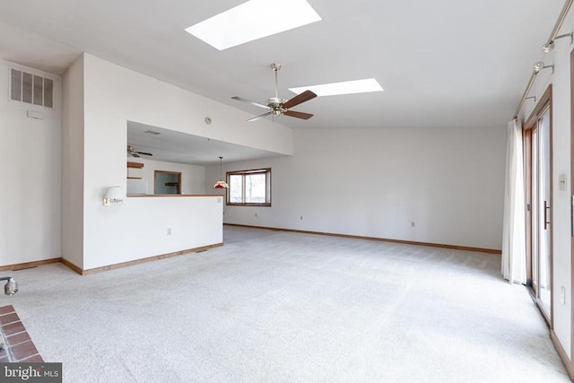 unfurnished living room with a skylight, carpet, ceiling fan, baseboards, and vaulted ceiling