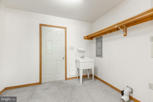 laundry room with electric panel, baseboards, and carpet flooring