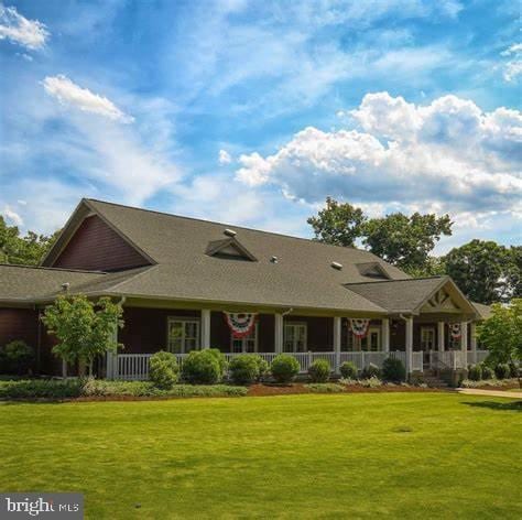 rear view of property featuring a porch and a yard