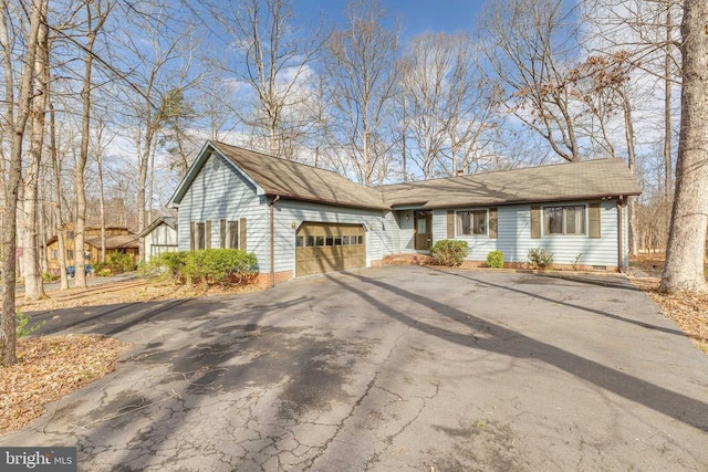 ranch-style home featuring asphalt driveway, an attached garage, and crawl space