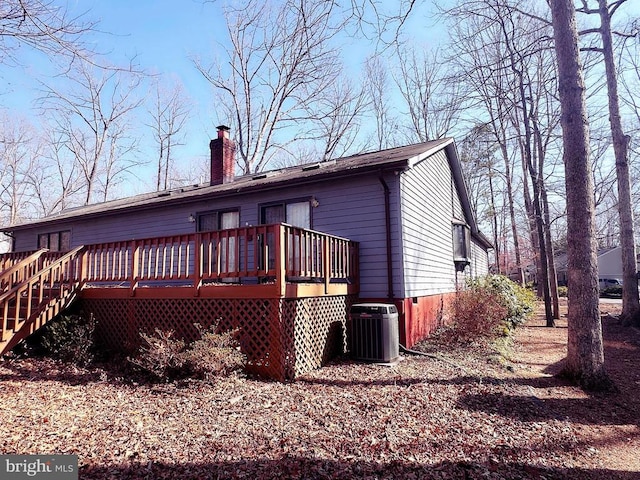 back of house with a chimney, central air condition unit, and a deck