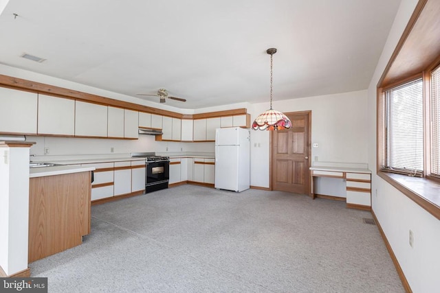 kitchen featuring black range with gas stovetop, freestanding refrigerator, light carpet, and white cabinets