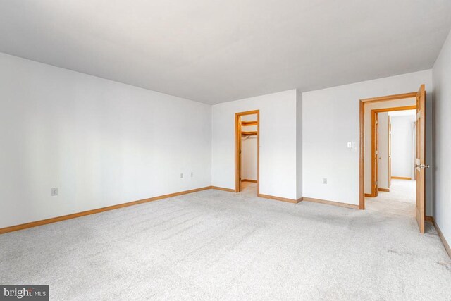 empty room featuring light carpet and baseboards