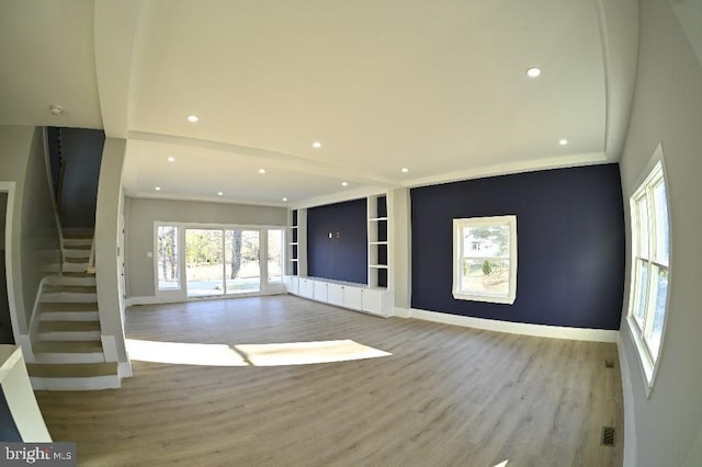 unfurnished living room with stairway, recessed lighting, baseboards, and wood finished floors