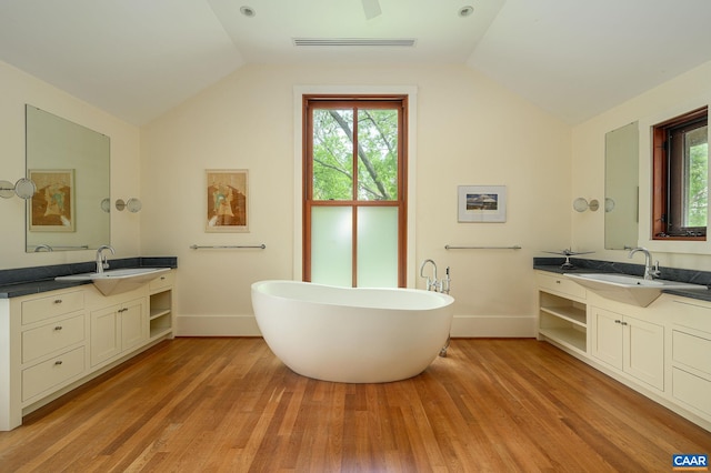 1112 Park St, Charlottesville, VA 22901 - bathroom with lofted ceiling, wood finished floors, plenty of natural light, a freestanding bath, and two vanities