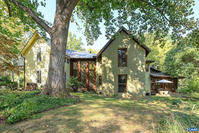 1112 Park St, Charlottesville, VA 22901 - rear view of house featuring a lawn, stucco siding, and a metal roof