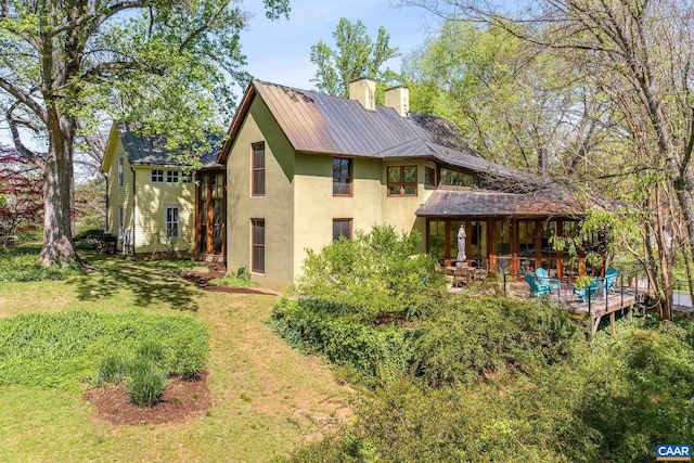 1112 Park St, Charlottesville, VA 22901 - back of house with stucco siding, a chimney, a metal roof, and a yard