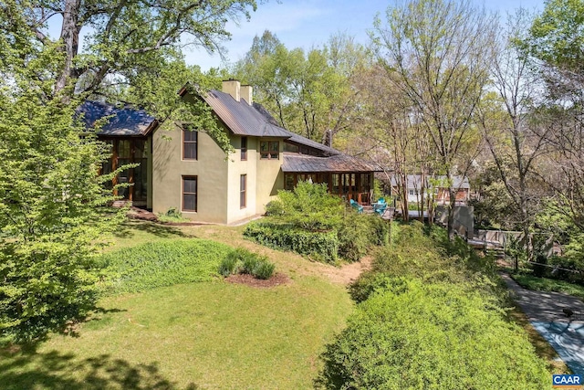 1112 Park St, Charlottesville, VA 22901 - view of property exterior with stucco siding, a metal roof, a chimney, and a yard