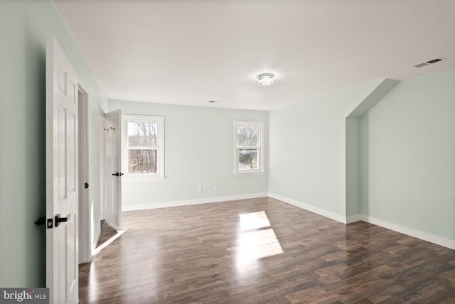 unfurnished room featuring wood finished floors, visible vents, and baseboards