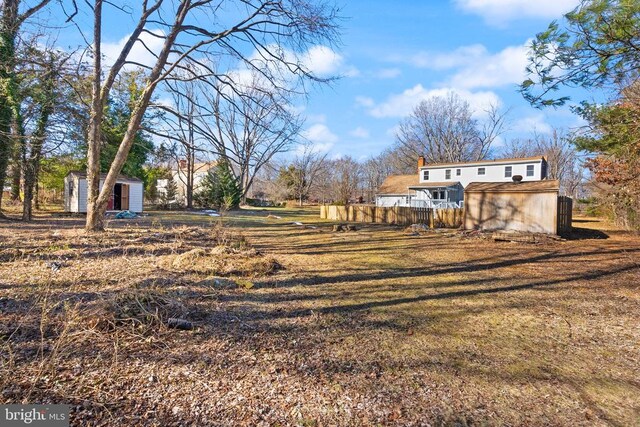 view of yard with an outbuilding, a shed, and fence