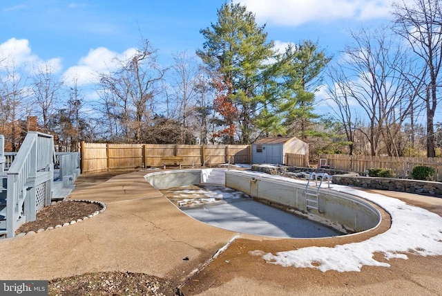 view of swimming pool with a patio area, a storage unit, an outbuilding, and a fenced backyard