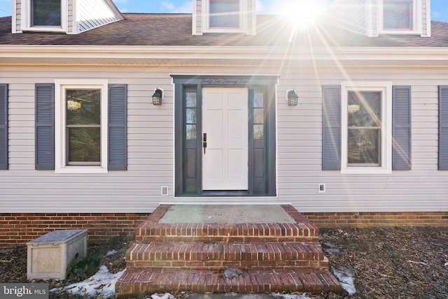 property entrance featuring roof with shingles