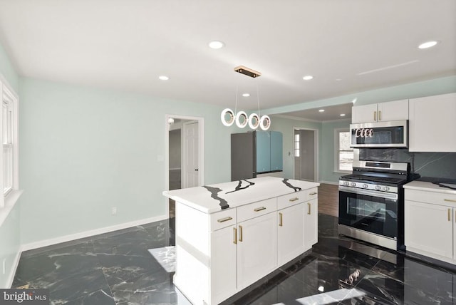 kitchen with stainless steel appliances, baseboards, marble finish floor, and white cabinetry