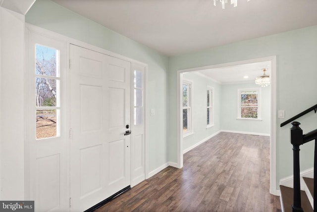 foyer with baseboards, dark wood finished floors, and stairs