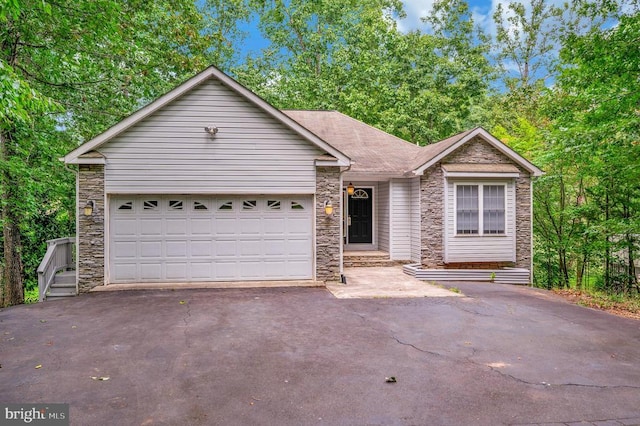 ranch-style house with stone siding, asphalt driveway, and a garage