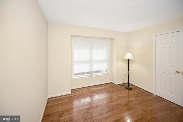 unfurnished room with wood finished floors and baseboards