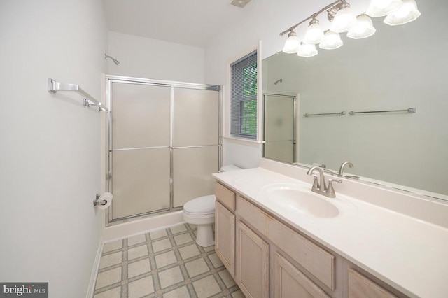bathroom featuring tile patterned floors, a stall shower, toilet, and vanity
