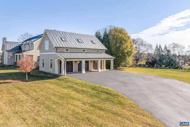 modern farmhouse style home with a porch, driveway, a front yard, and a standing seam roof