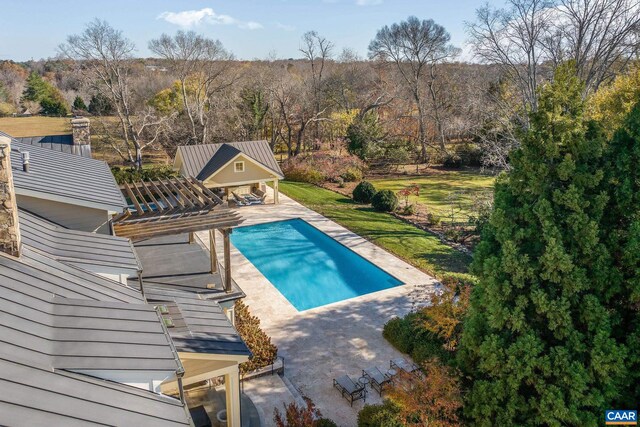 outdoor pool with a patio, an outbuilding, and an exterior structure