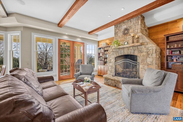 living room with wood walls, beam ceiling, light wood-type flooring, recessed lighting, and a fireplace
