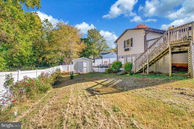 view of yard with a deck and a storage unit