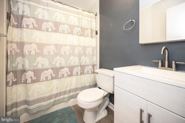 bathroom featuring vanity, hardwood / wood-style flooring, toilet, and a shower with shower curtain