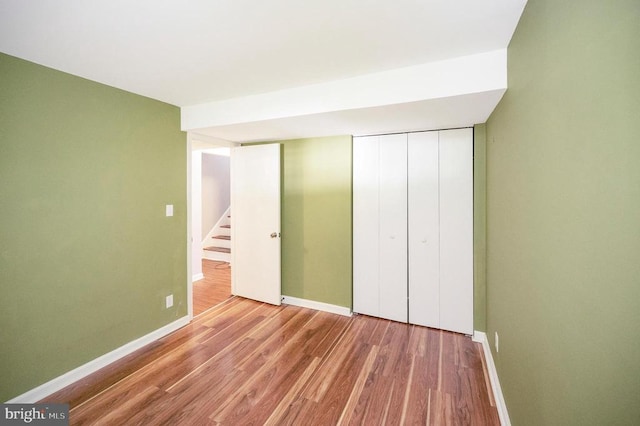 unfurnished bedroom with light hardwood / wood-style floors and a closet