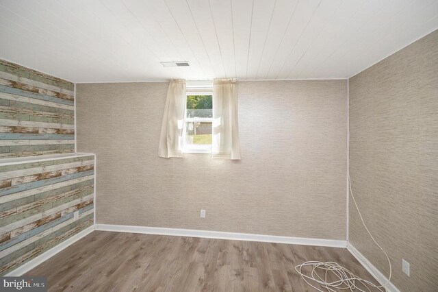 spare room with wood-type flooring and wooden ceiling