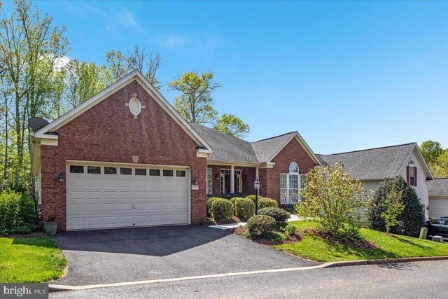  - single story home with aphalt driveway, a garage, and brick siding
