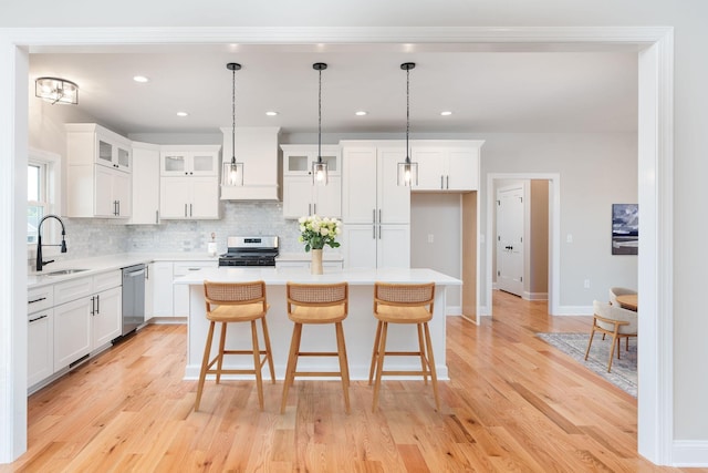 409 Peterson Ln, Waynesboro, VA 22980 - kitchen featuring stainless steel appliances, a sink, decorative backsplash, a kitchen island, and light countertops