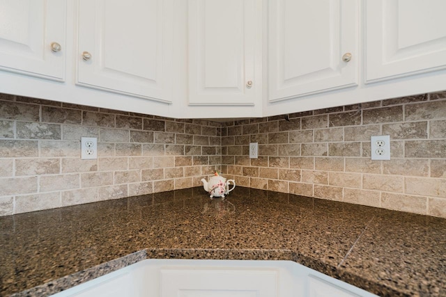 kitchen view of white cabinets and decorative backsplash