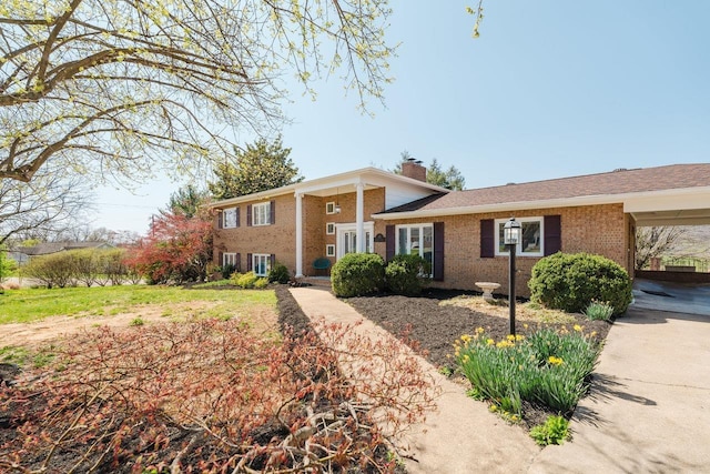 tri-level home with a chimney and brick siding