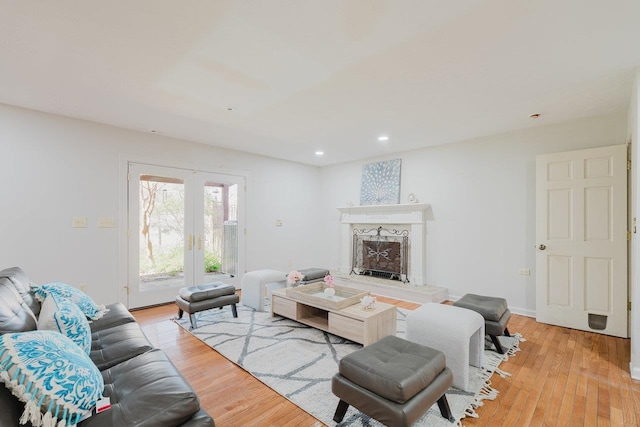 living area with light wood-type flooring, a premium fireplace, and recessed lighting