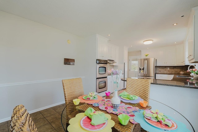 kitchen with appliances with stainless steel finishes, a sink, white cabinets, tasteful backsplash, and recessed lighting
