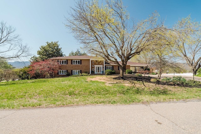 view of front of home featuring a front lawn and brick siding